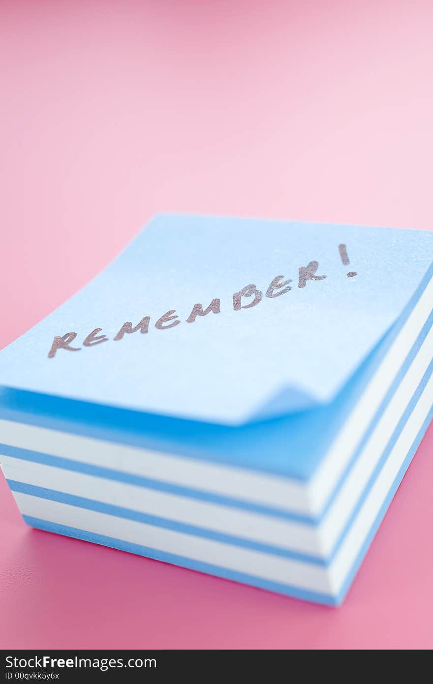 Pile of sticky notes with meeting reminder text over a pink table