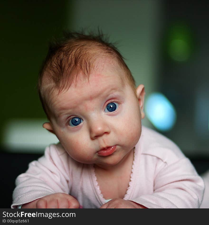 Little wondering infant lying on the bed