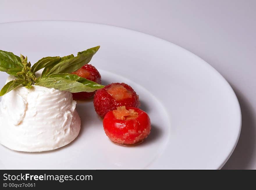 A detailed shoot of an isolated italian cheese ricotta whit basil red hot chili peppers