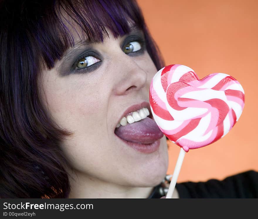 Close-up of an Alternative Girl with a Heart Lollipop