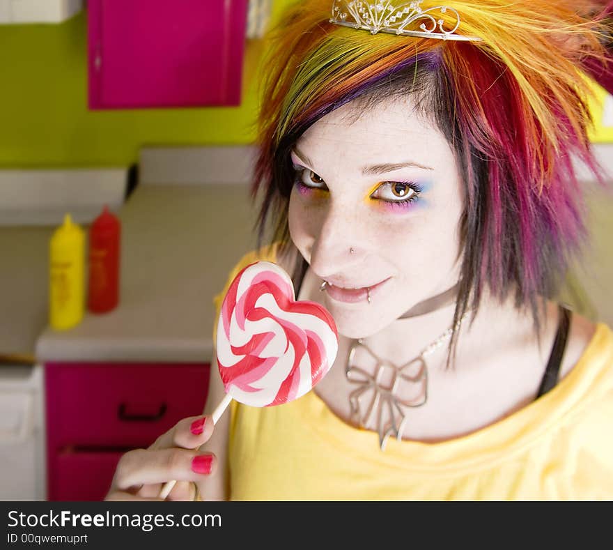 Alternative Girl in a Colorful Kitchen with a Heart Lollipop. Alternative Girl in a Colorful Kitchen with a Heart Lollipop