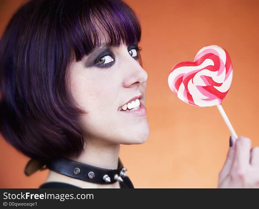 Close-up of an Alternative Girl with a Heart Lollipop