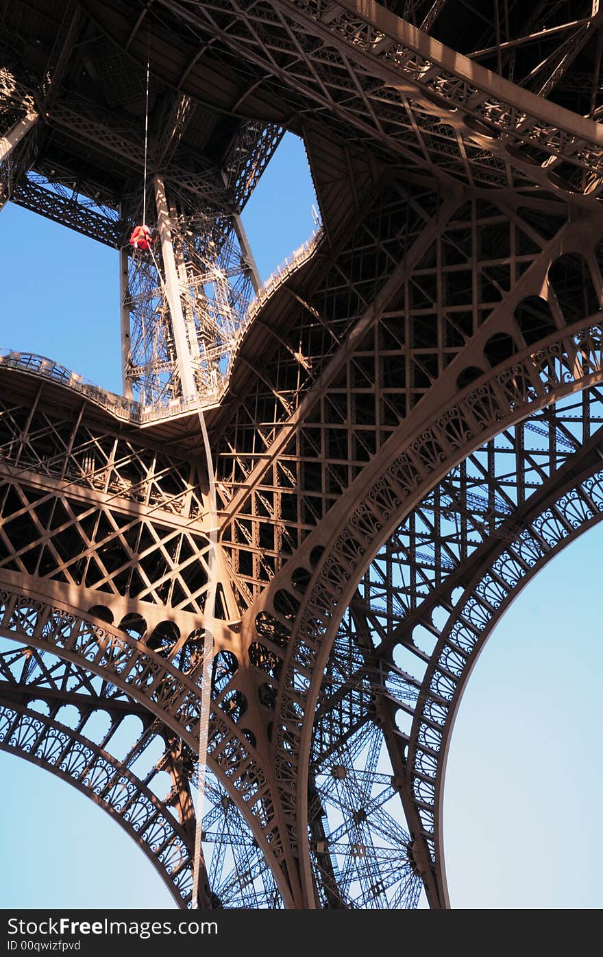 Eiffel Tower in Paris on a clear spring day in February with a deep blue sky. A man clamping. Eiffel Tower in Paris on a clear spring day in February with a deep blue sky. A man clamping