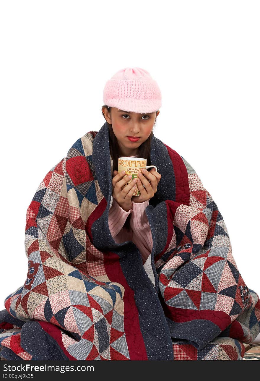 Lady sipping a hot coffee while her body covered wtth quilt