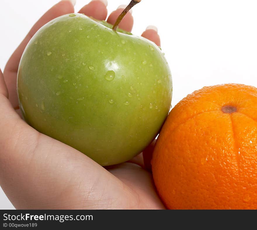 Fresh green apple and orange held by a woman