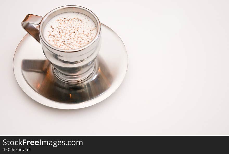 Cup and saucer with coffee drink and garnish on white tablecloth. Cup and saucer with coffee drink and garnish on white tablecloth.