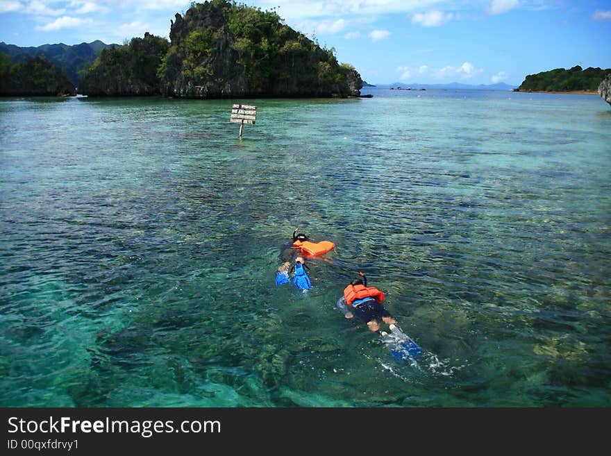 Two snorkelers exploring the beauty of underwater marine life. Two snorkelers exploring the beauty of underwater marine life