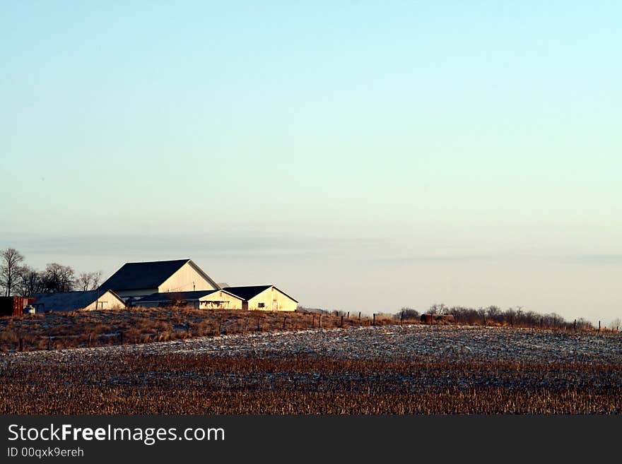 A field with a farmhouse in the distance. A field with a farmhouse in the distance.