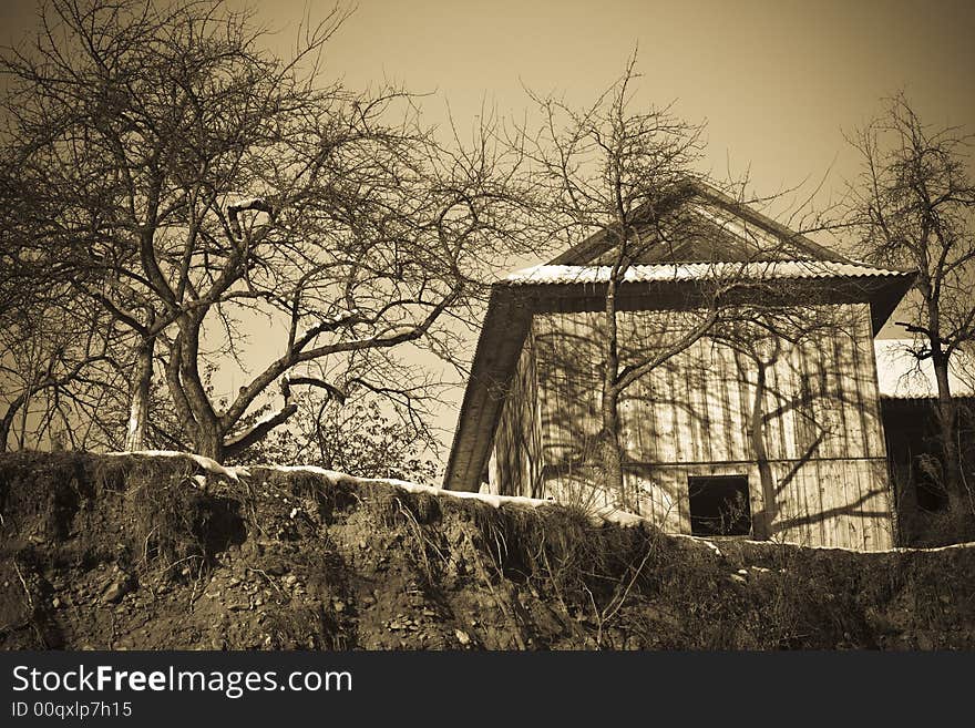 Sepia toned old-fashioned vintage village house with trees. Sepia toned old-fashioned vintage village house with trees