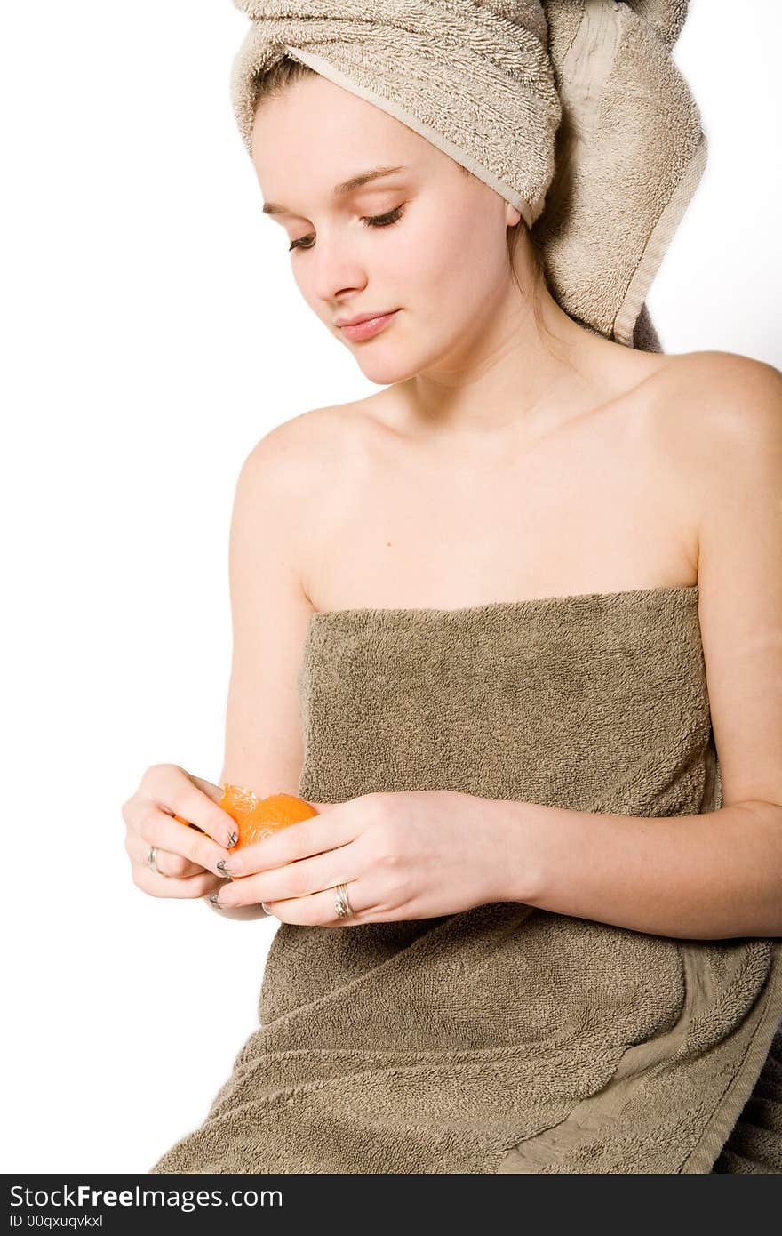 Young woman on a white background  in towel caring for herself. Young woman on a white background  in towel caring for herself