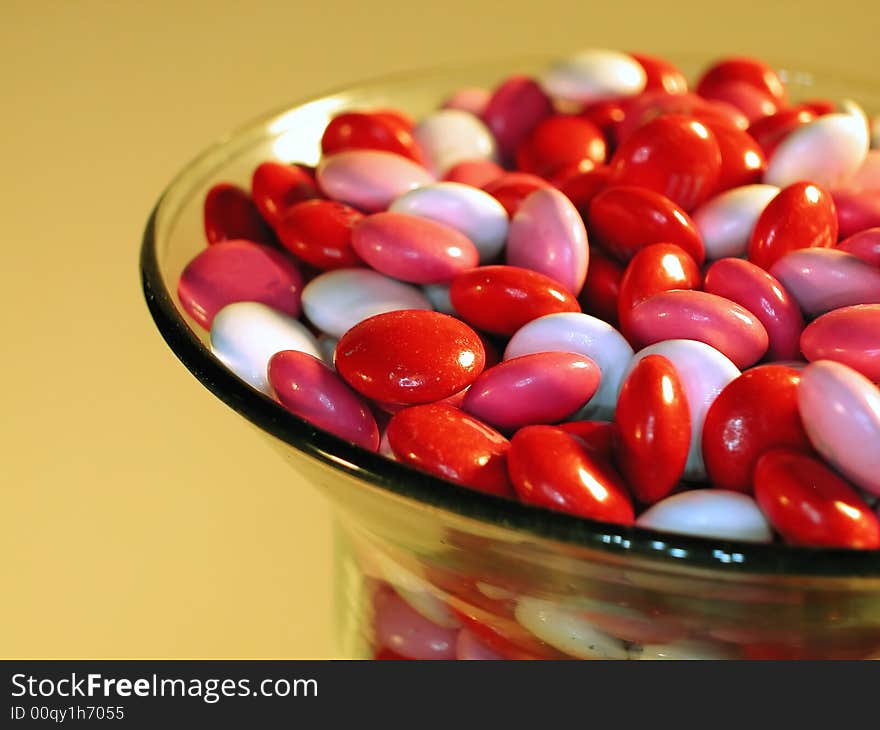 A glass dish full of pink, white and red candy set out for Valentines day. A glass dish full of pink, white and red candy set out for Valentines day