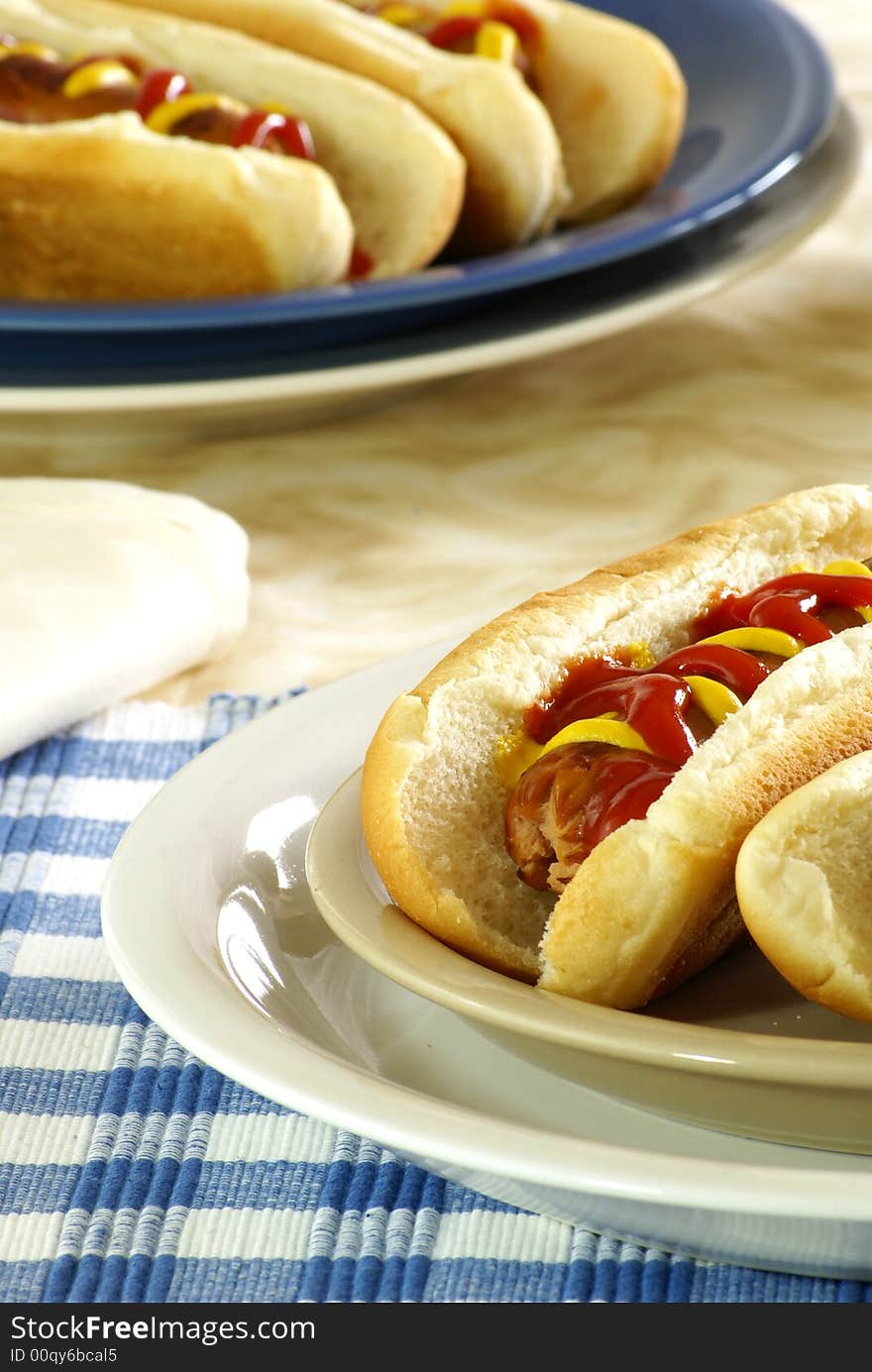 Fresh hotdogs with ketchup and mustard on buns. Fresh hotdogs with ketchup and mustard on buns.