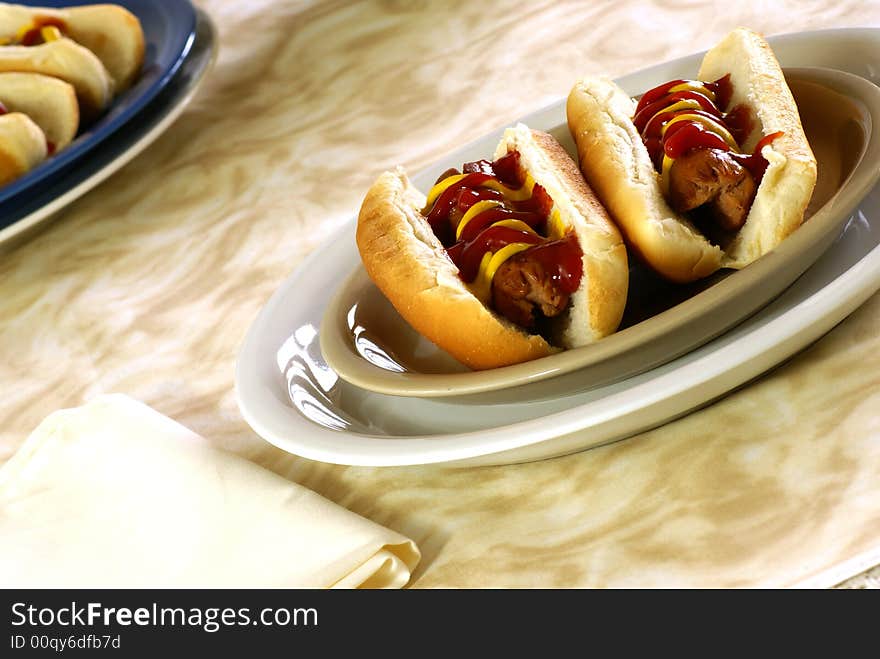 Fresh hotdogs with ketchup and mustard on buns. Fresh hotdogs with ketchup and mustard on buns.