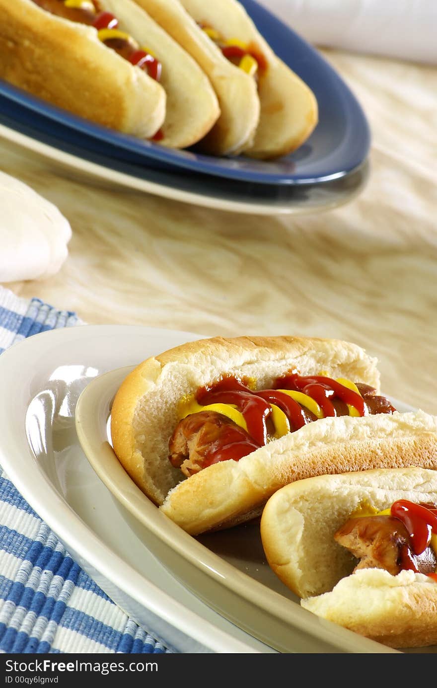 Fresh hotdogs with ketchup and mustard on buns. Fresh hotdogs with ketchup and mustard on buns.