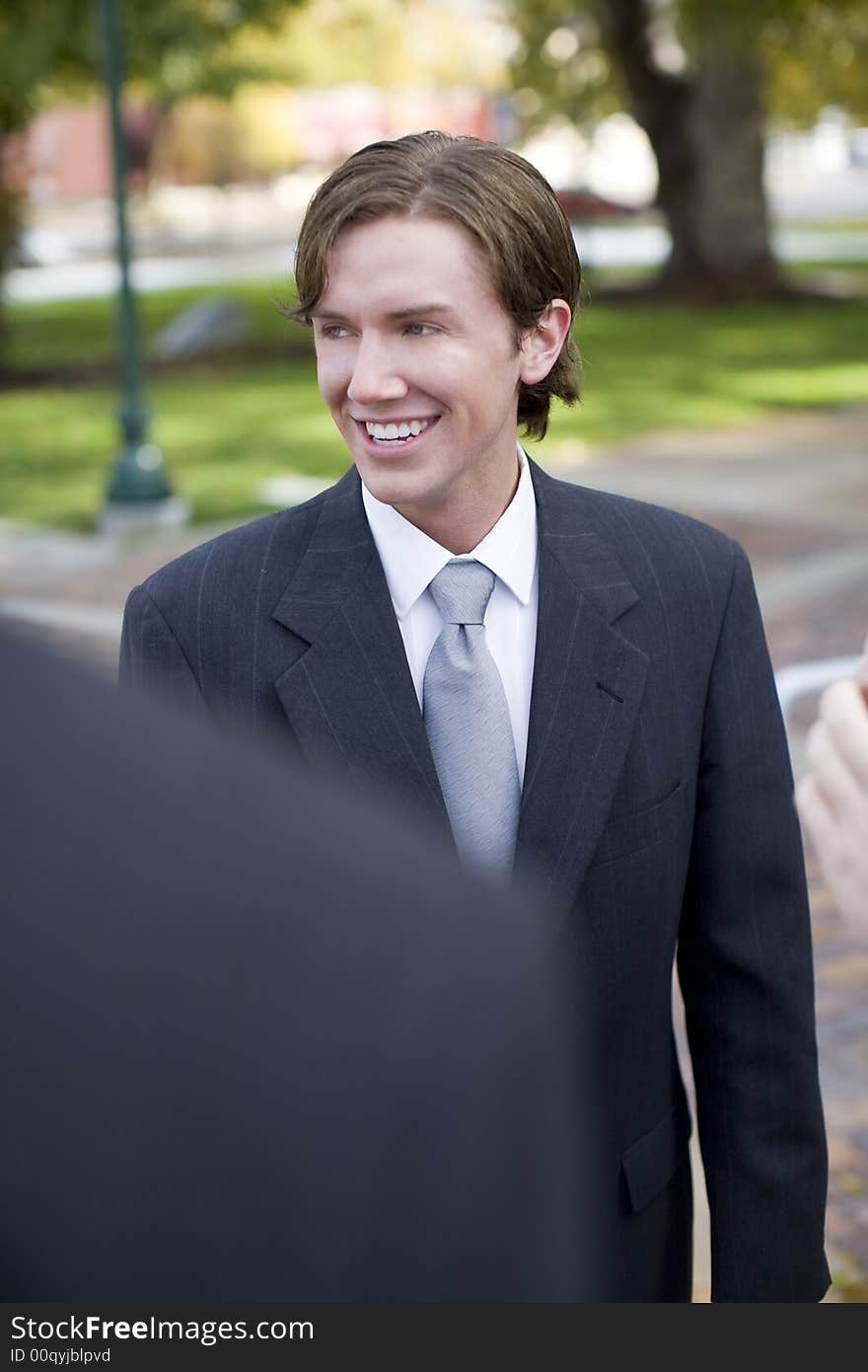 Over shoulder view of two businessman standing and smiling. Over shoulder view of two businessman standing and smiling