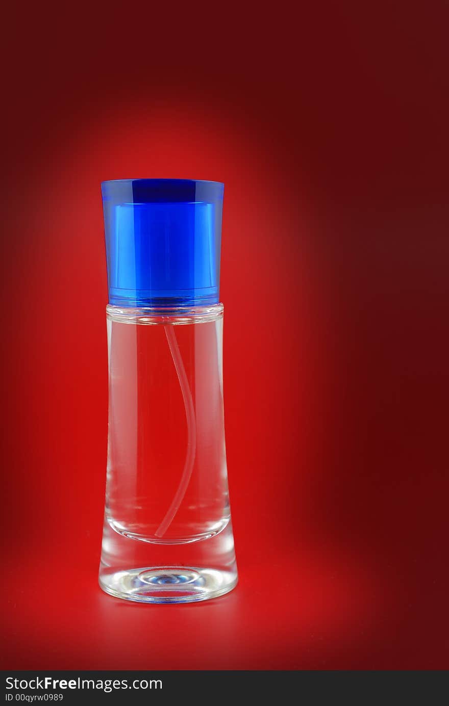 Perfume. A bottle perfume on a red background with effective illumination. Perfume. A bottle perfume on a red background with effective illumination