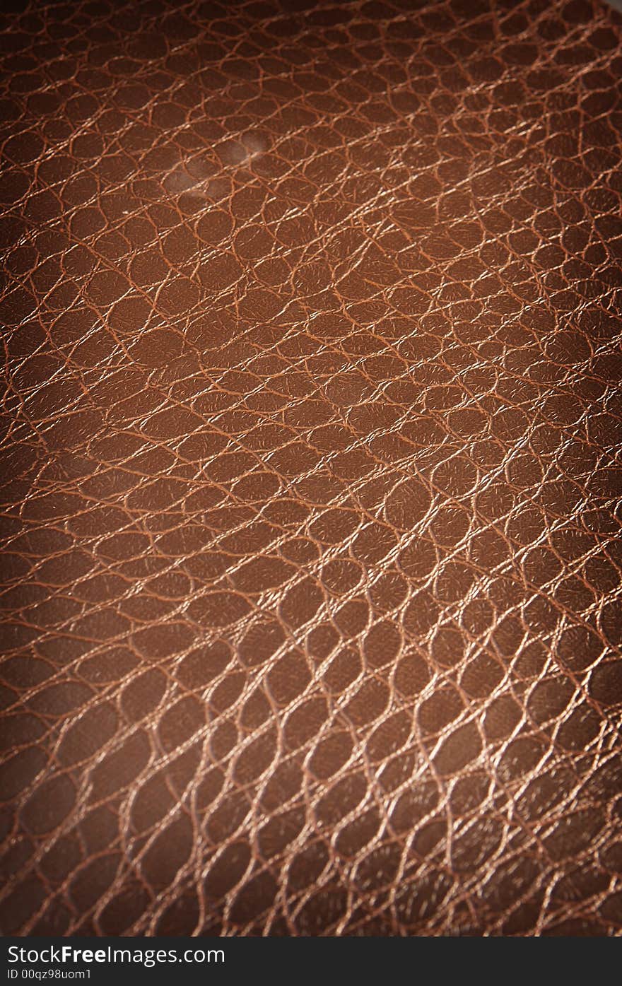 Dark brown crackled leather background close up shot at an angle