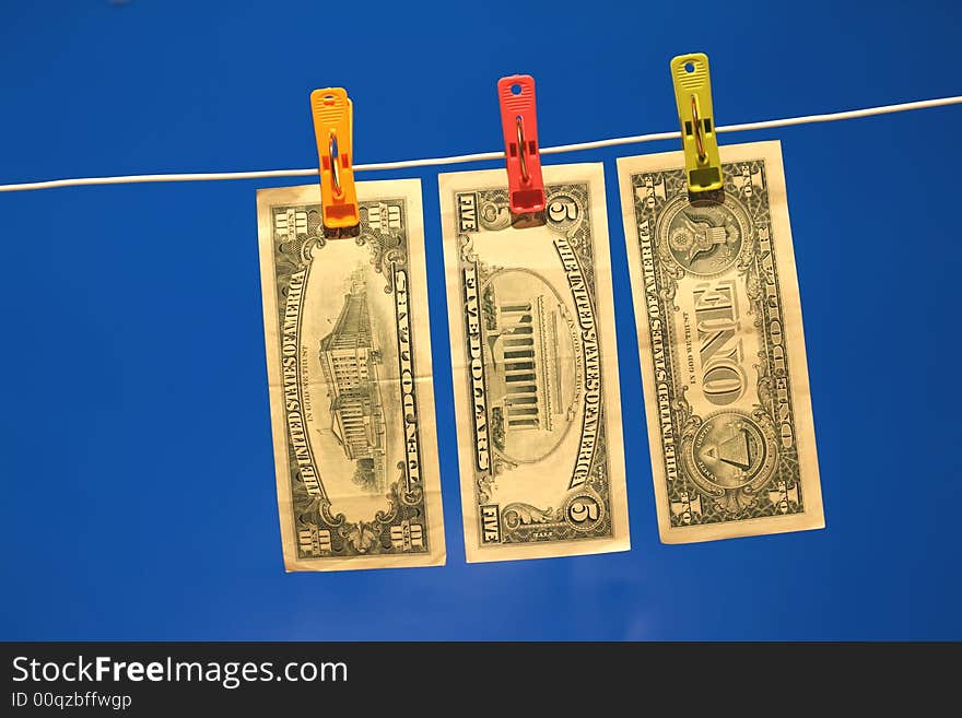 Dollar bills on a washing line, with a blue background. Dollar bills on a washing line, with a blue background