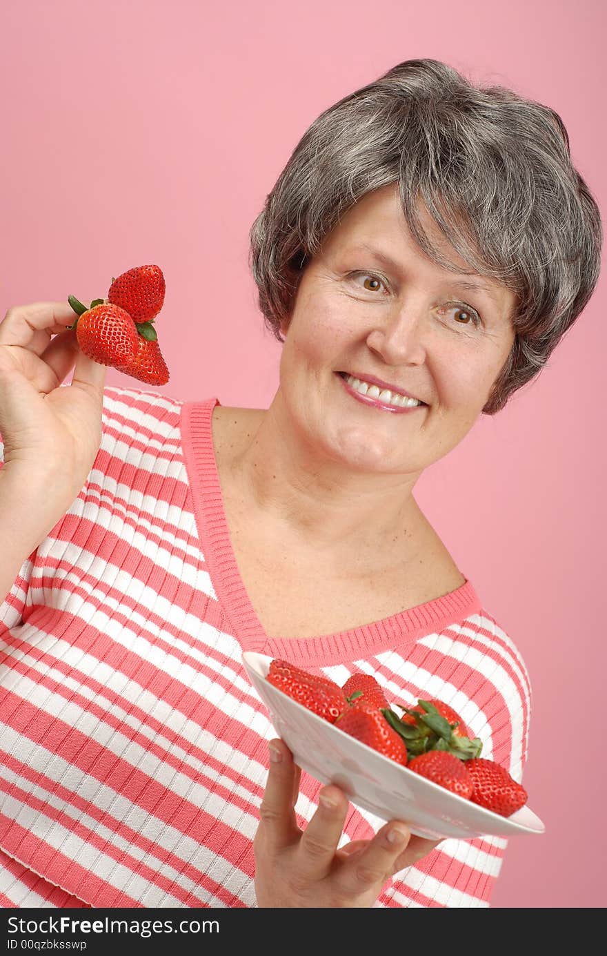 Healthy eating concept with senior holding strawberries. Healthy eating concept with senior holding strawberries