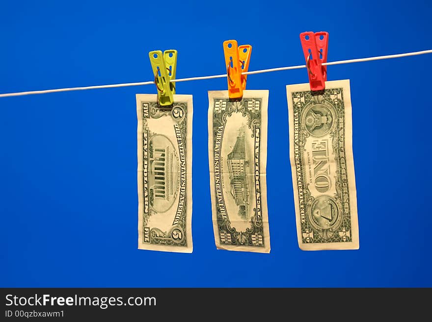 Dollar bills on a washing line, with a blue background. Dollar bills on a washing line, with a blue background