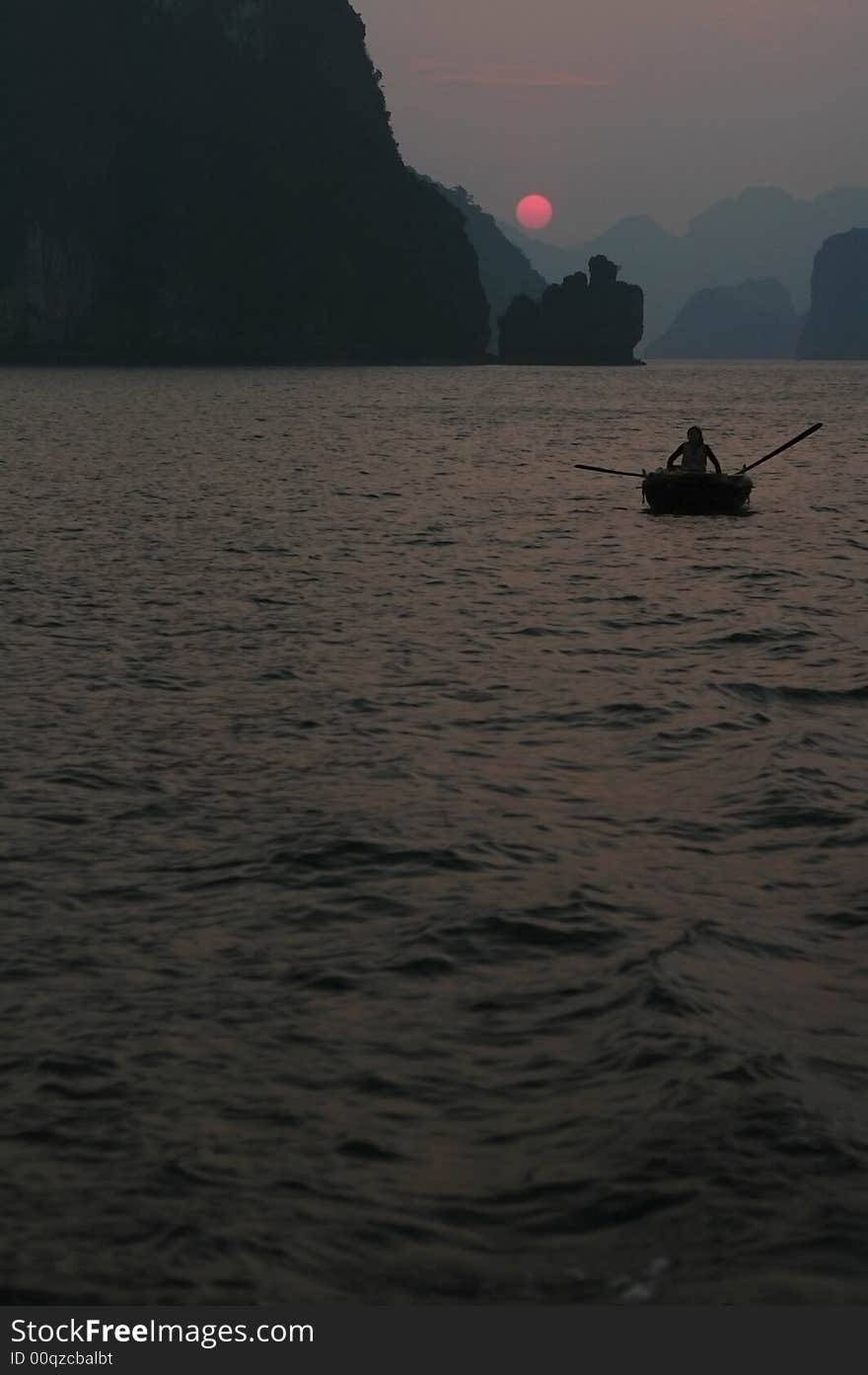 Woman in boat in halong Bay at sundown. Woman in boat in halong Bay at sundown