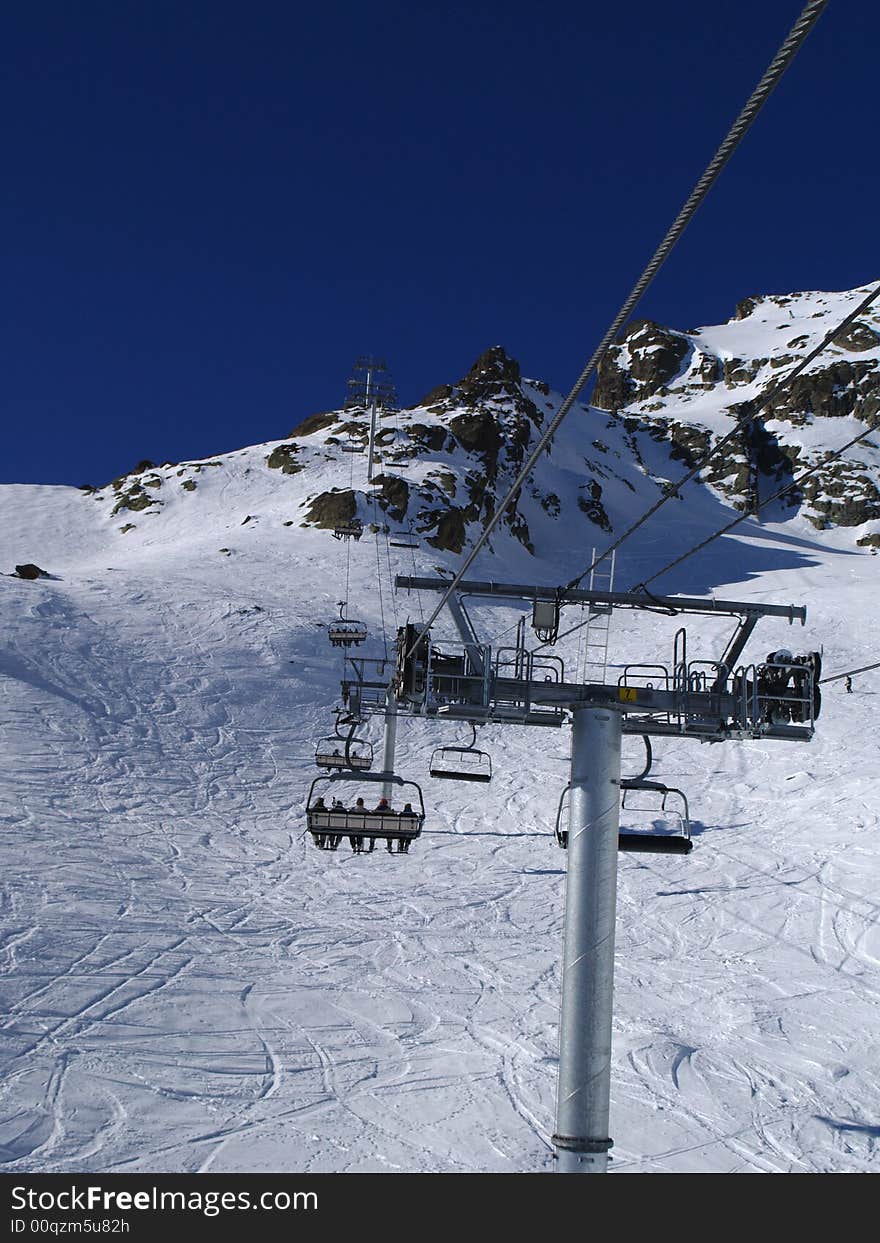 Ski lift with passengers and ski trail