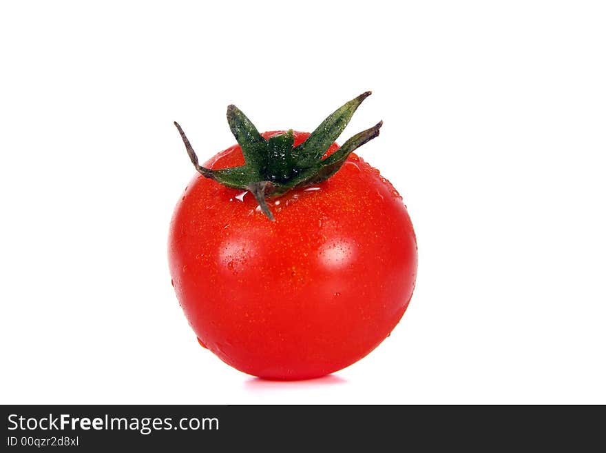 A red tomato with waterdrops over white background.