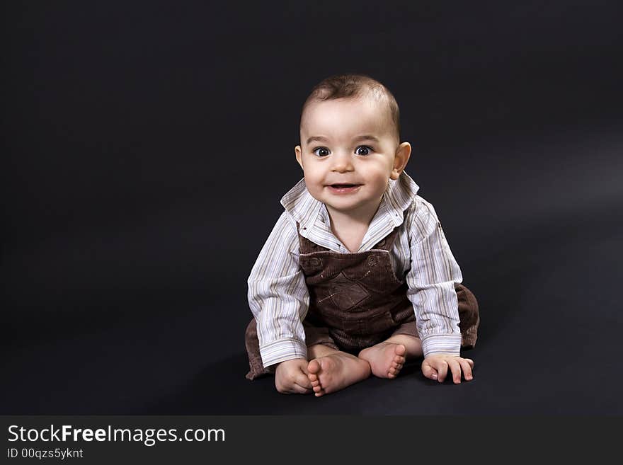 Curious happy baby on black surface