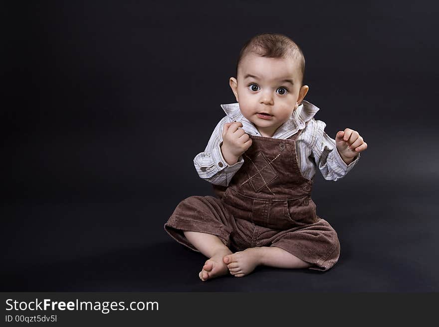 Curious happy baby on black surface