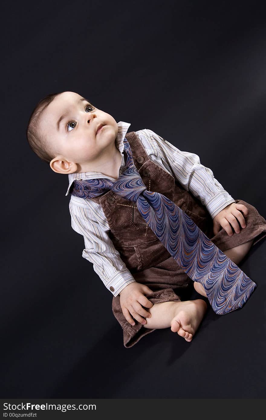 Curious happy baby on black surface