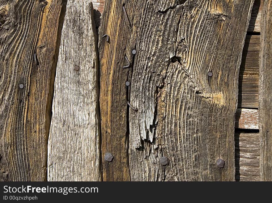 A weathered wooden wall with rusty nails. A weathered wooden wall with rusty nails