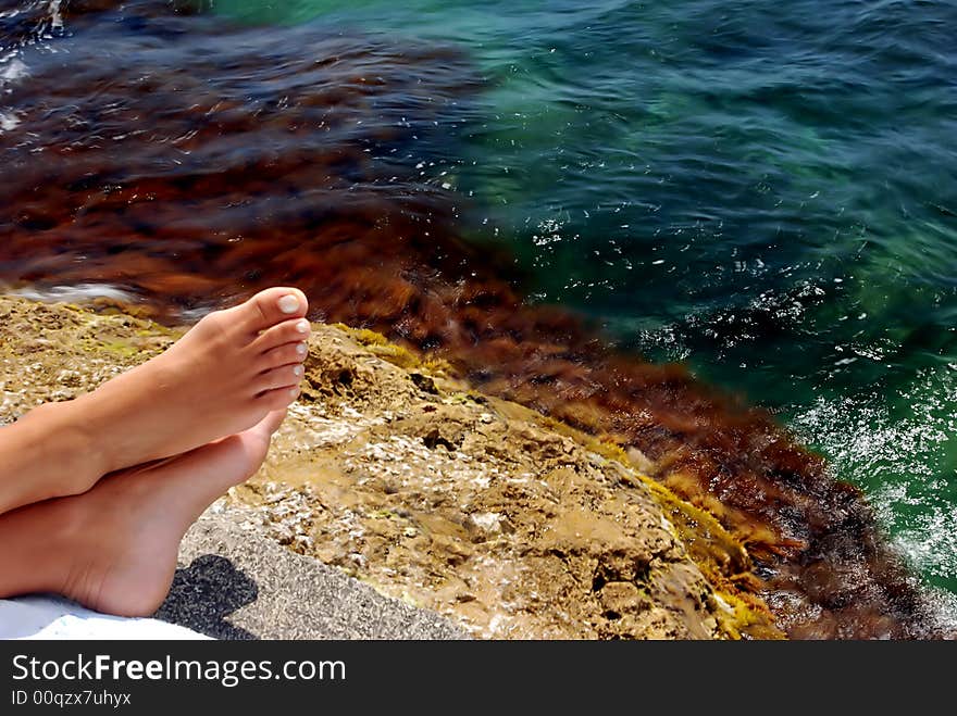 Suntanned steps on a towel, summer, blue-green sea, sun. Suntanned steps on a towel, summer, blue-green sea, sun