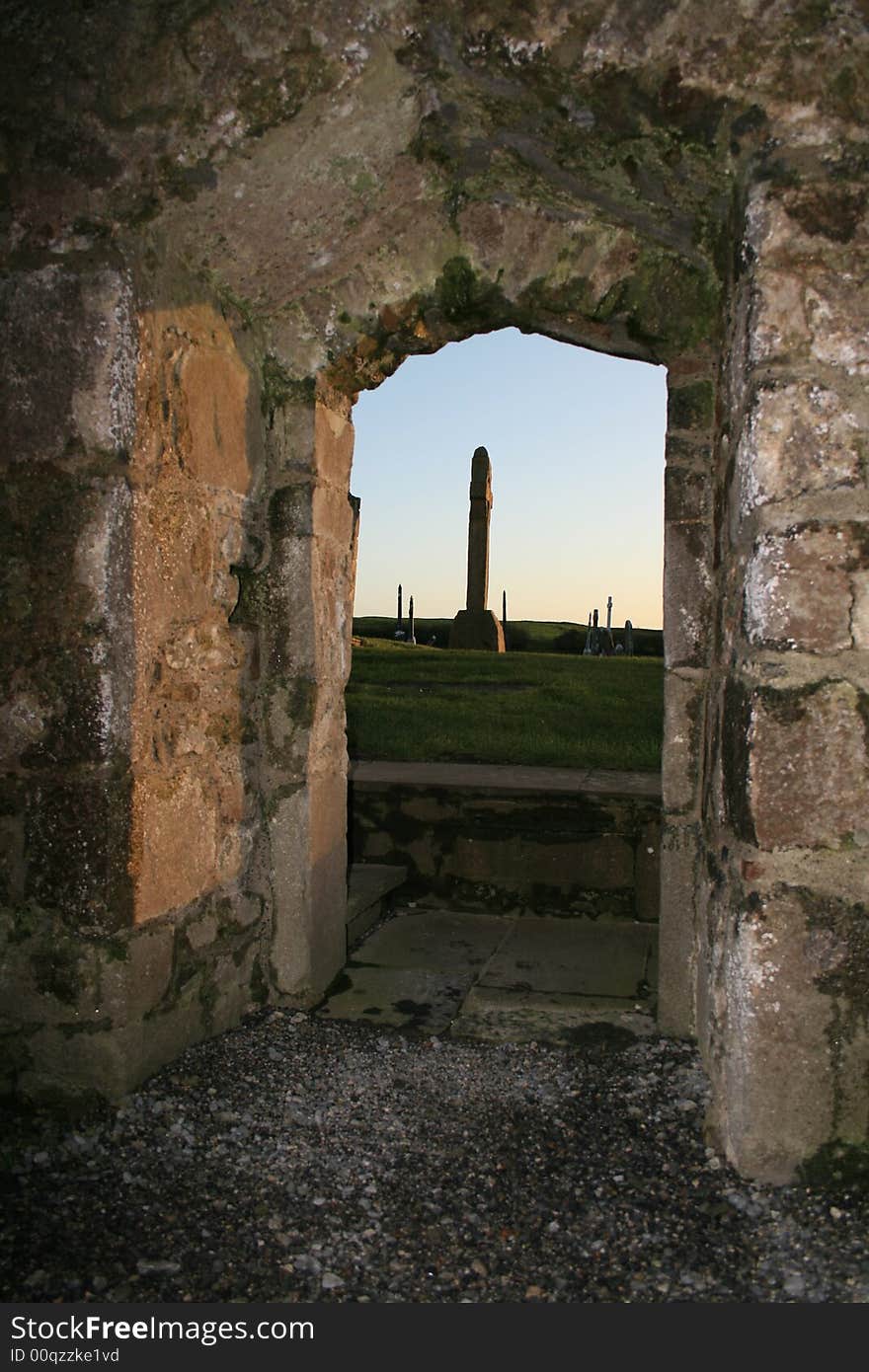 View of old cemetery through the door of a historic 10th century church ruins in Ireland. View of old cemetery through the door of a historic 10th century church ruins in Ireland