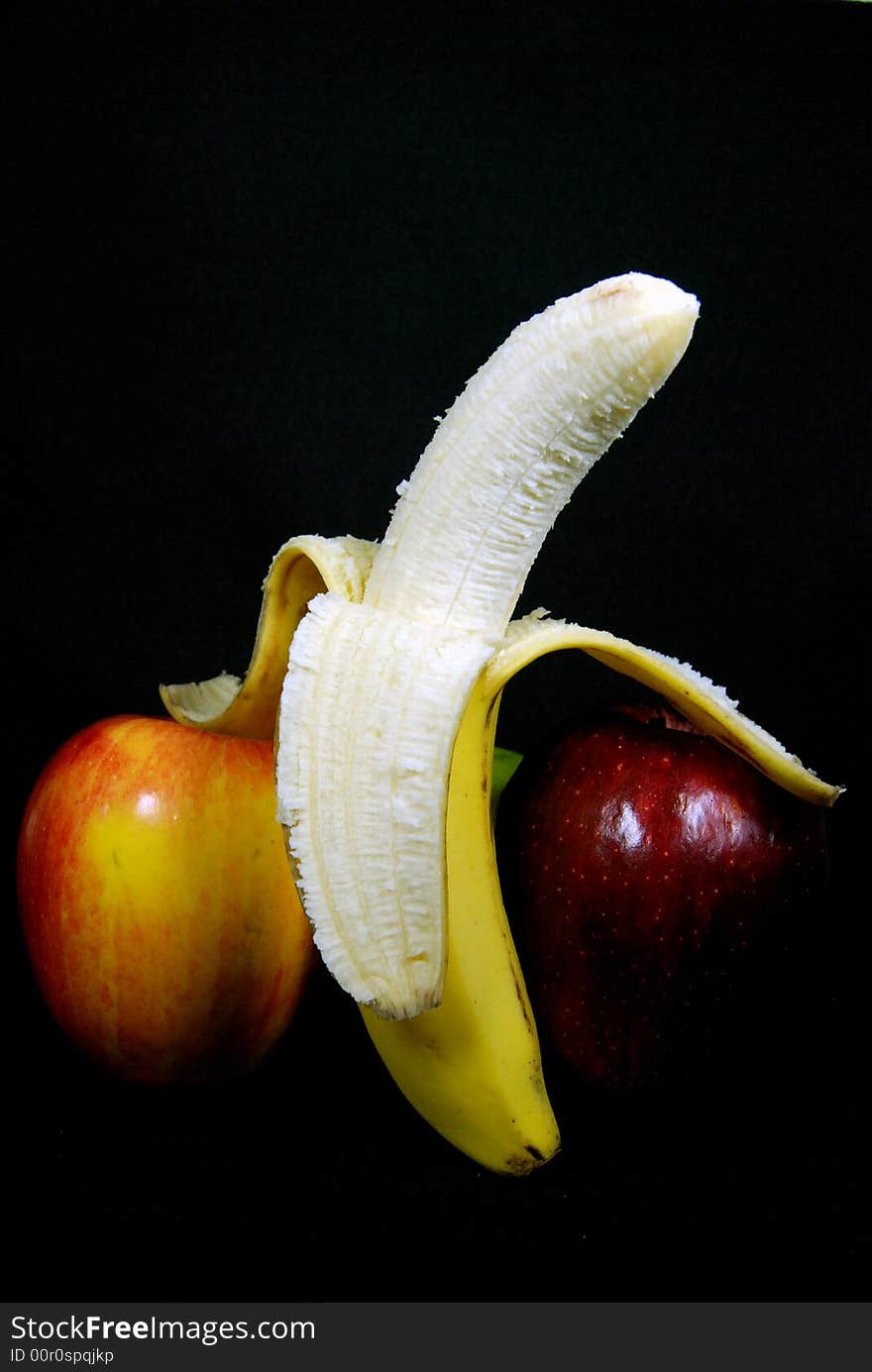 Ripe banana and polished apples on black. Ripe banana and polished apples on black.