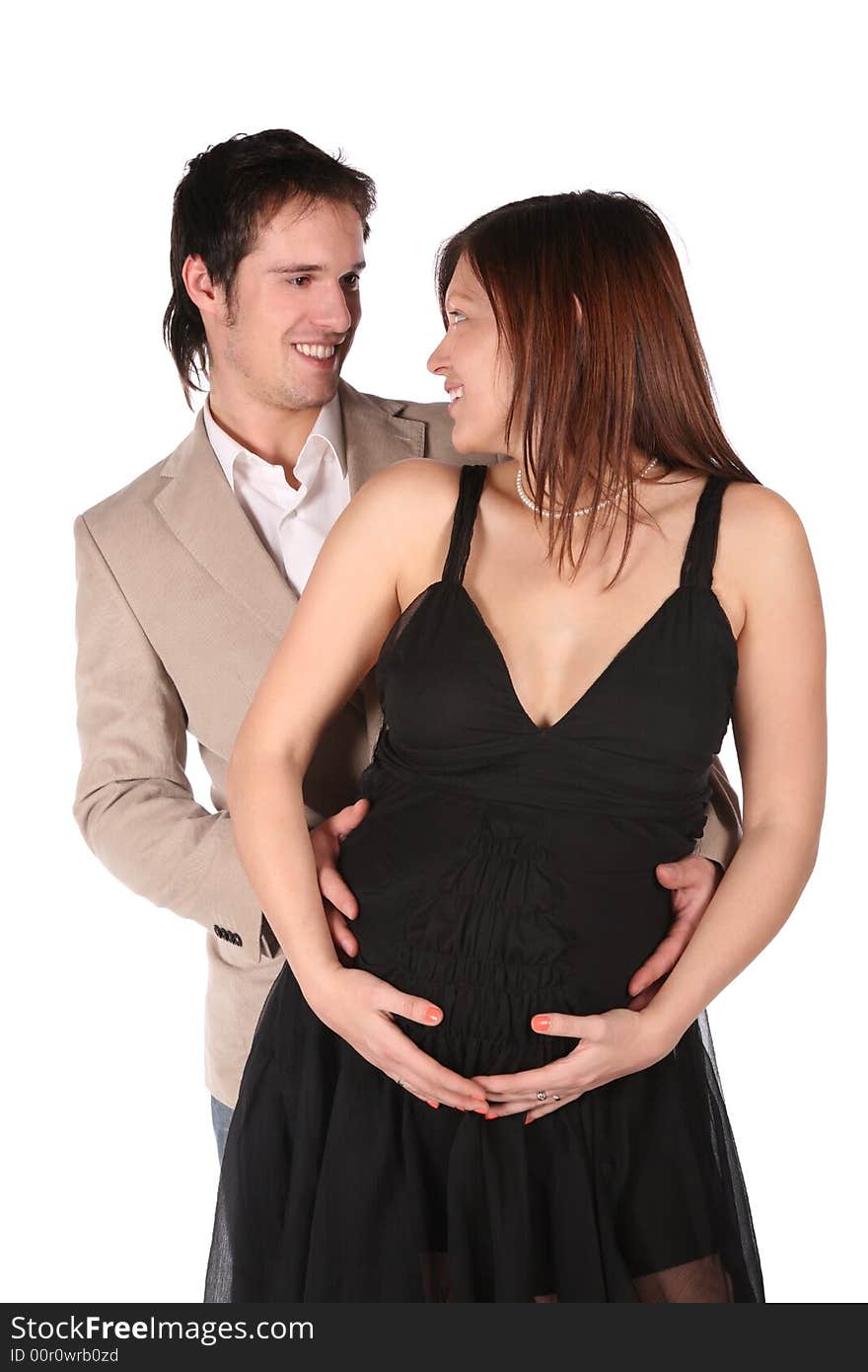 Pregnant couple embrace on white