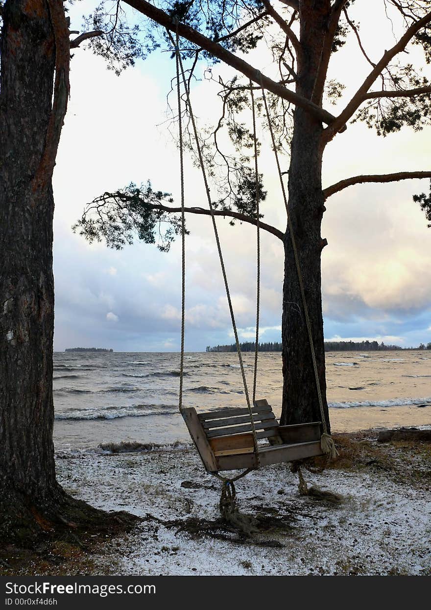 Empty swing near lake, autumn