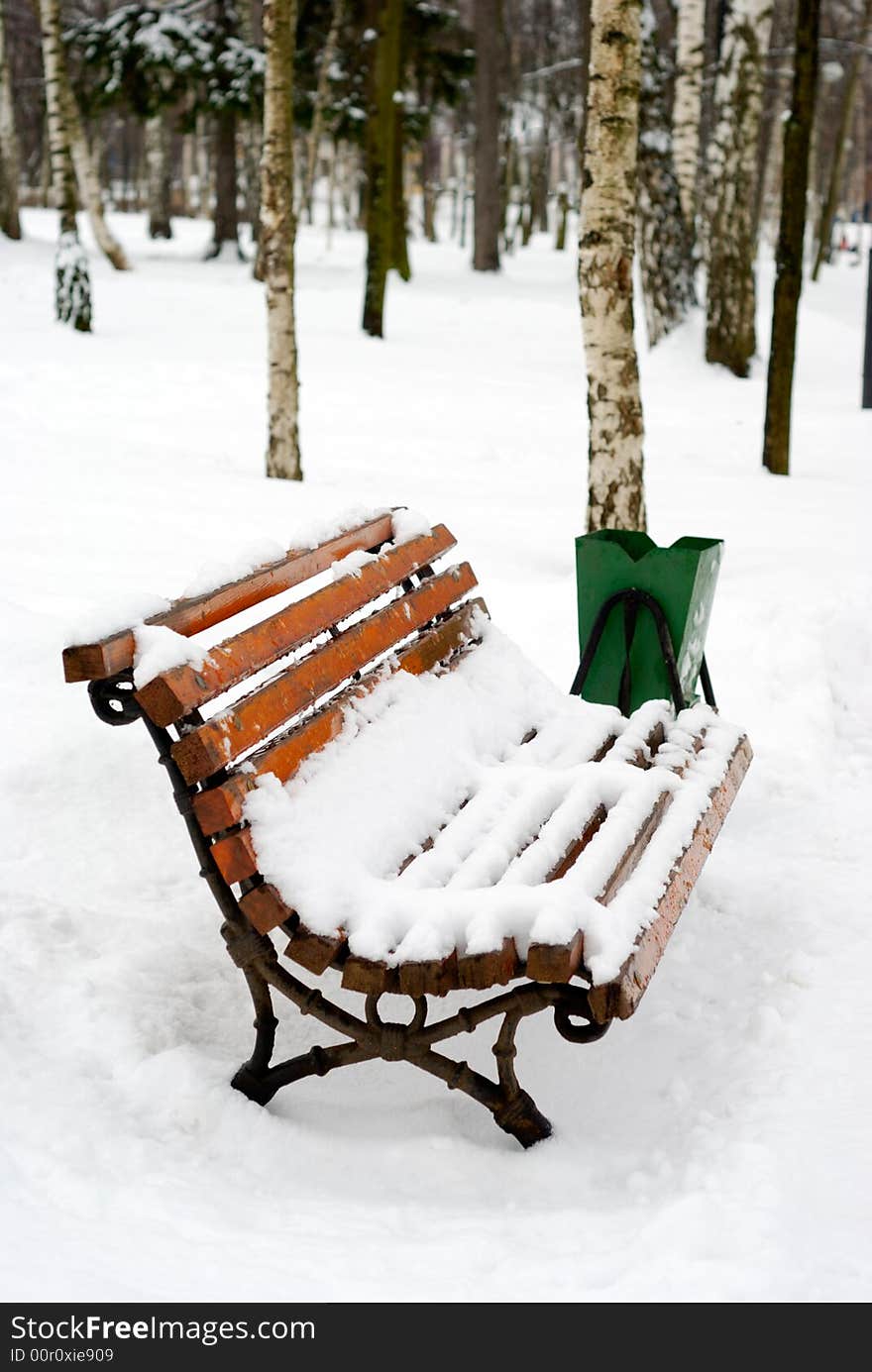 Old bench covered with snow. Park scene. Old bench covered with snow. Park scene.