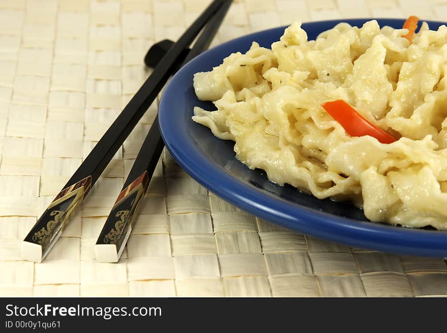 Chinese noodles with vegetables and chopsticks