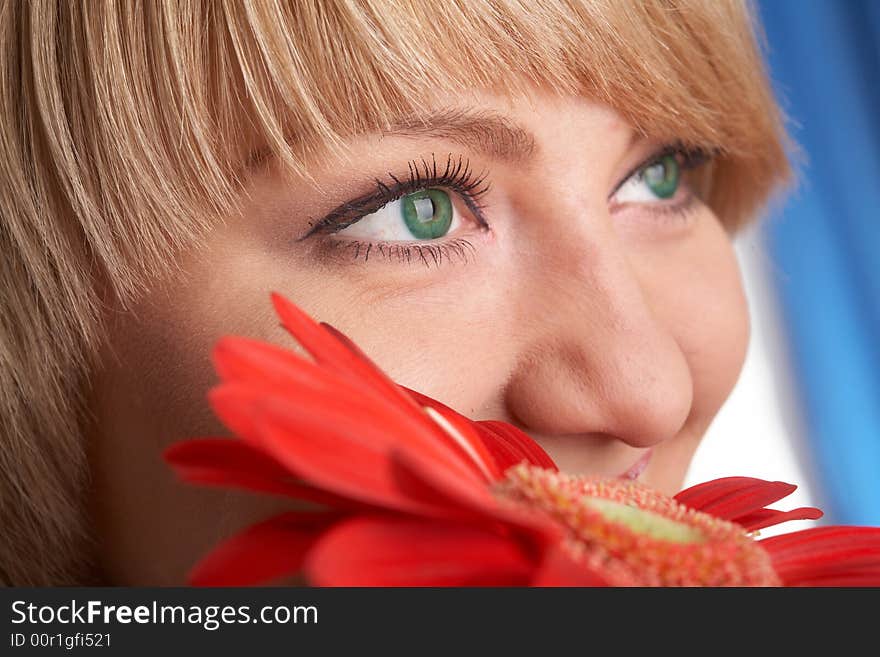 Girl's green eyes and a red flower close-up