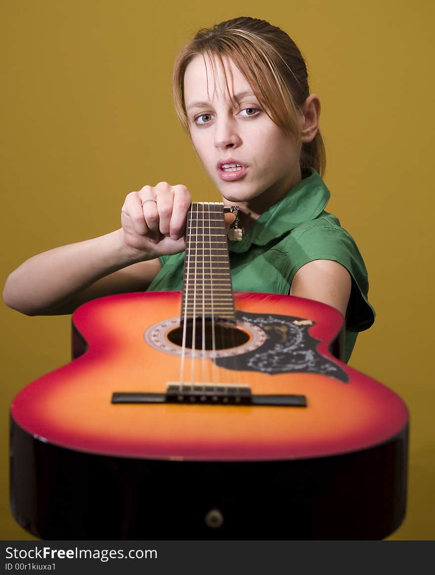 Girl in green dress with guitar in hands. Girl in green dress with guitar in hands