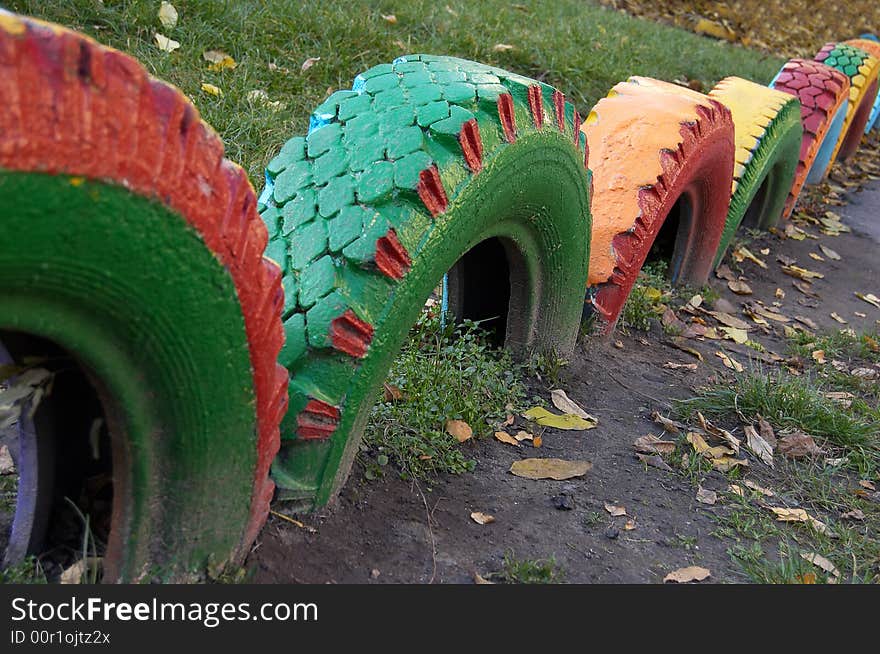 Multi-coloured wheels are dug in the ground. Multi-coloured wheels are dug in the ground