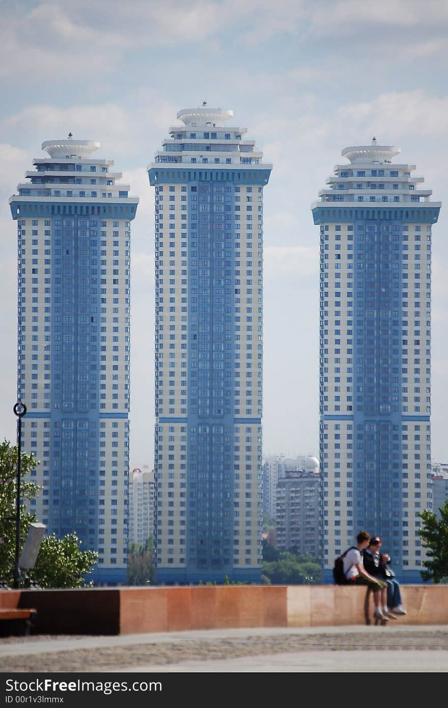 Two people sitting in front of three skyscrapers