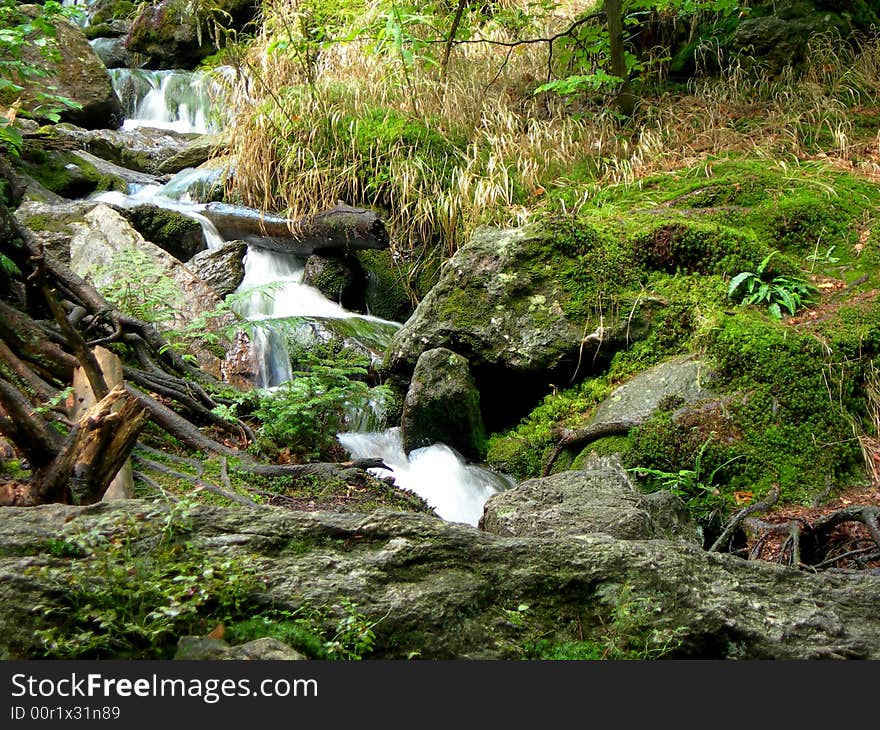 Wild mountain brook with stones and long exposure