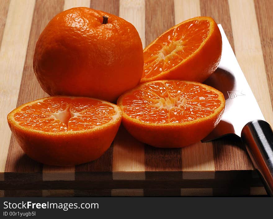 Fresh mandarin orange cutted&whole and knife on a wood cutting board. Fresh mandarin orange cutted&whole and knife on a wood cutting board