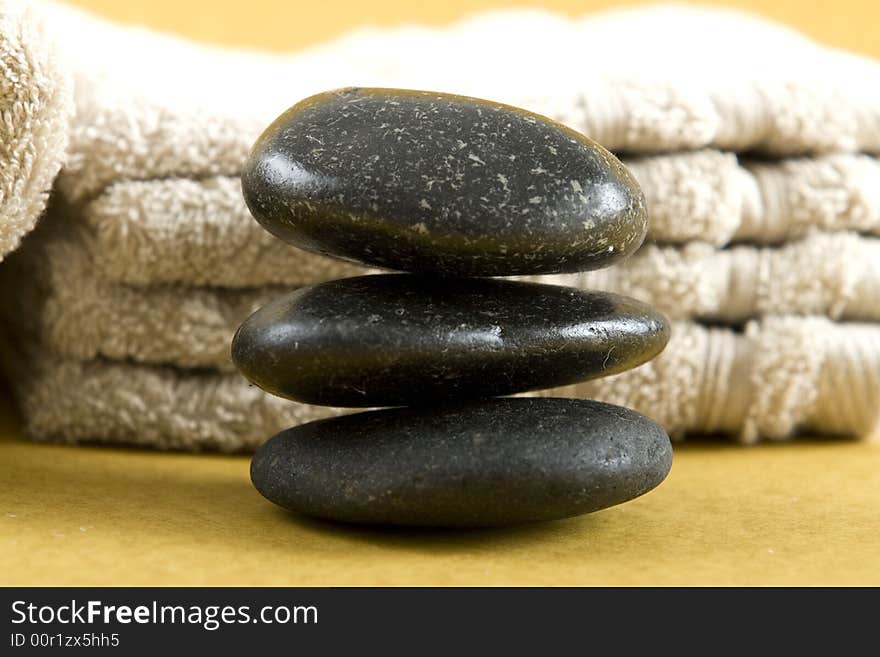 Zen Stones with white towels and fresh rose petals on earth color background