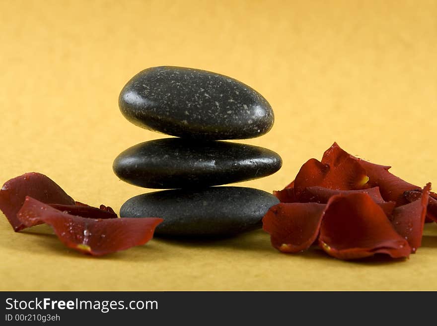 Zen Stones with white towels and fresh rose petals on earth color background