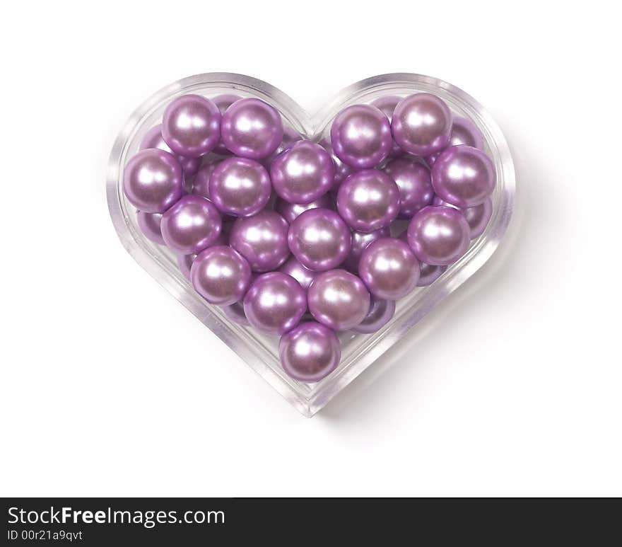 Heart-shaped plastic box with pink pearls in it. Heart-shaped plastic box with pink pearls in it.