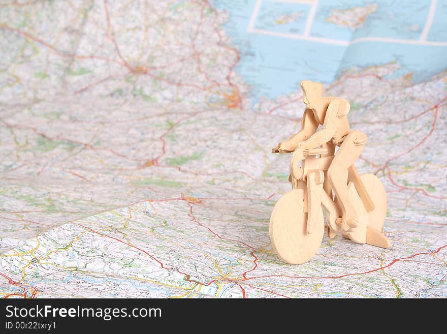 Wooden model of bicyclist on background of map. Wooden model of bicyclist on background of map