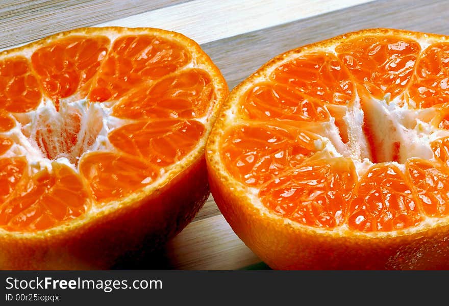 Fresh mandarin orange cutted in half on a wood cutting board. Fresh mandarin orange cutted in half on a wood cutting board