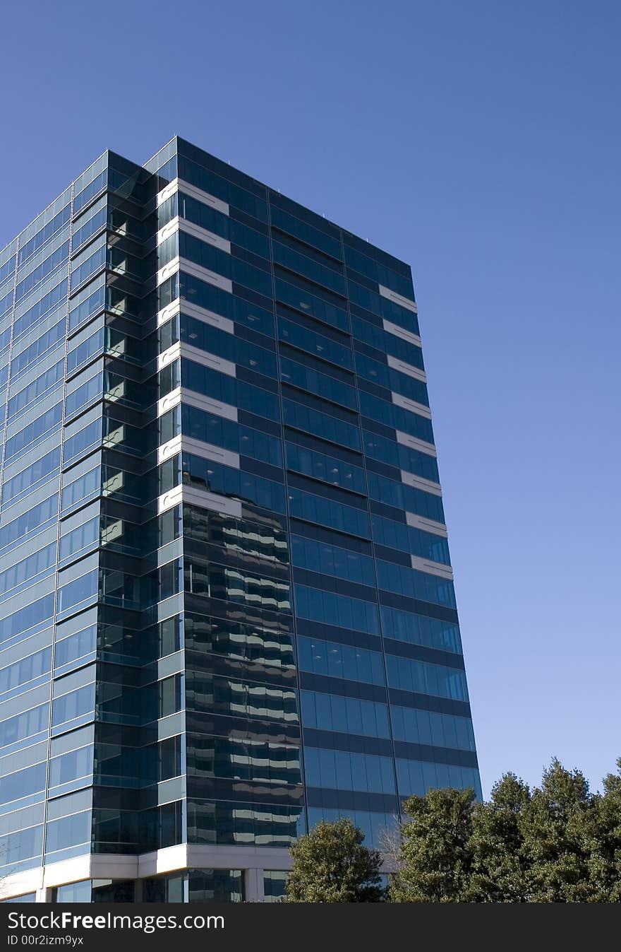 A blue and white glass office tower against the sky. A blue and white glass office tower against the sky